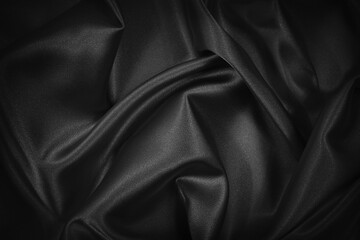 Black silk satin texture background. Beautiful wavy soft folds on shiny smooth fabric. Anniversary,...