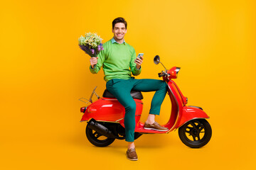Plakat Full body portrait of handsome guy sit on moped hold flower wear green style isolated on yellow color background