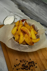 Golden baked new potatoes for dinner. Ketchup sauce and sour cream.