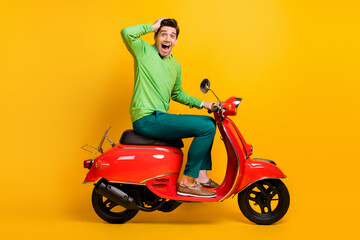 Fototapeta na wymiar Full size profile portrait of impressed person on moped hand on head open mouth isolated on yellow color background