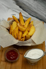 Golden baked new potatoes for dinner. Ketchup sauce and sour cream.