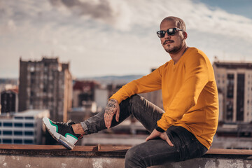 Urban hipster young man posing on top of the ghetto building