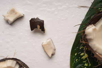 Pieces of chopped coconut close up on white table, close up