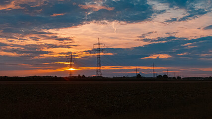 Beautiful summer sunset with high voltage overhead lines near Aholming, Bavaria, Germany