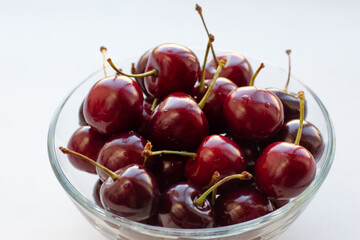 Juicy sweet cherries in a glass bowl isolated on white