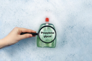 A bottle of Liquid soap floating in soapy water. Harmful ingredients, detergent with Propylene glycol. The concept of hazardous substances in cosmetics and household chemicals