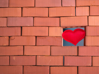 Smooth heart building in the wall from rough, textured bricks