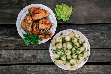 fried chicken and young potatoes with dill.simple rural dish.wooden background.top view