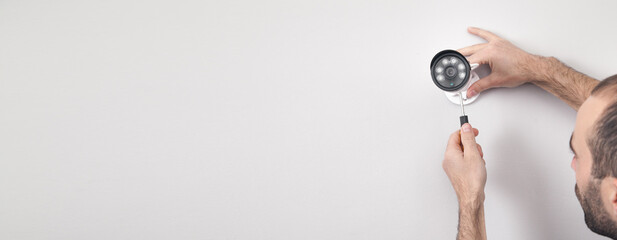 Technician installing CCTV camera system for home.