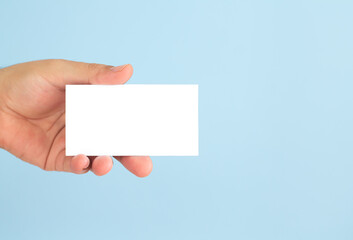 Fototapeta premium Businessman hand holding blank business card on blue background