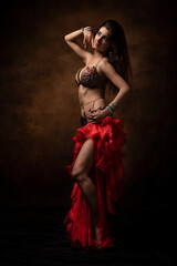 Oriental dancer with a saber. Belly dance. The brunette. Red.
