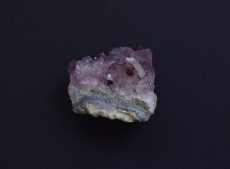 Beautiful druse of natural purple mineral amethyst on a gray background. Large crystals of a gem.