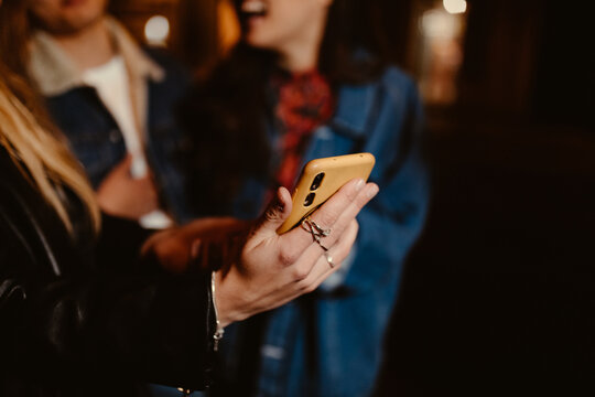 close-up of woman holding phone in her hand at night