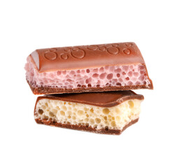 Mix of porous chocolate pieces isolated on white background. White and pink aerated chocolate.