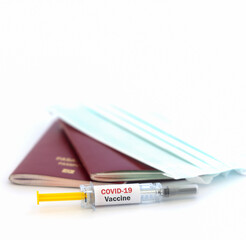 Selective focus, Vaccine passport for travelling during the Covid-19 pandemic concept with face mask and syringe on White background. 