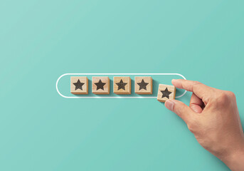 Improve rating, increase ranking, improve customer satisfaction  concept. Hand putting wooden blocks with star icon in progress bar on turquoise background. - obrazy, fototapety, plakaty