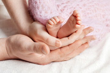 Parents holding baby feet close-up. Baby feet in mother and father hands. Mom, Dad and Child. Happy family concept.