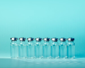 Ampoules with Covid-19 vaccine on blue background. Coronavirus sars-cov-2 pandemic.