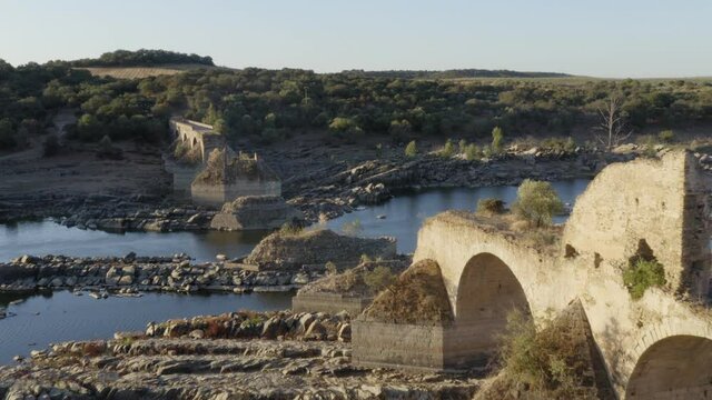 Destroyed abandoned Ajuda bridge drone aerial view, crossing the Guadiana river between Spain and Portugal