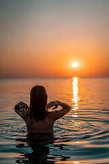 Young beautiful woman having fun in water at beach. Summer photo of young beautiful girl in sea swimming and having fun. Female on beach enjoying sea vacation traveling