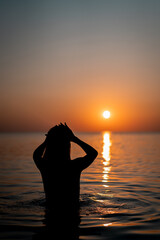 Young beautiful woman having fun in water at beach. Summer photo of young beautiful girl in sea swimming and having fun. Female on beach enjoying sea vacation traveling