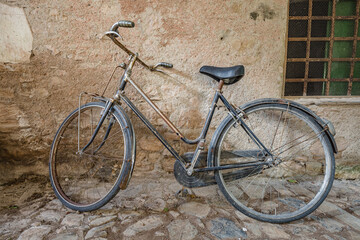View of forgotten old bike parked against the wall in one of the empty stone streets of an abandoned mountain village