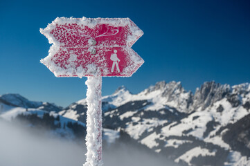 frozen winter hiking and snowshoe trail sign in front of Gastlosen, Switzerland