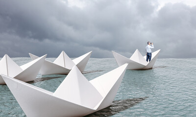 man on paper boat with binoculars