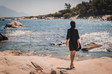 Young beautiful woman having fun in water at beach. Summer photo of young beautiful girl in sea swimming and having fun. Female on beach enjoying sea vacation traveling