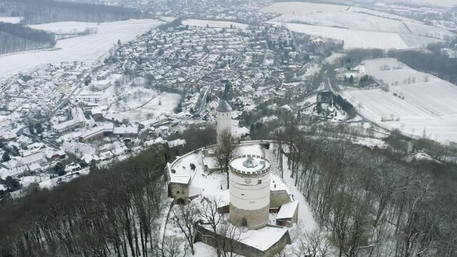 Drone aerial of the fairy tale castle Plesse in winter with a huge amount of snow on a beautiful mountain near Bovenden, Germany, Europe.