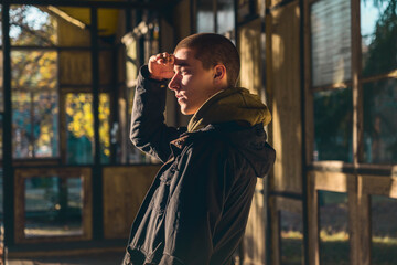 portrait of a young man in profile with evening sun looking out