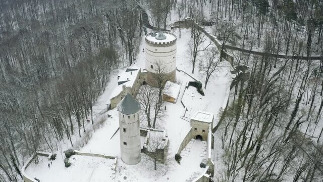 Drone aerial of the fairy tale castle Plesse in winter with a huge amount of snow on a beautiful mountain near Bovenden, Germany, Europe.