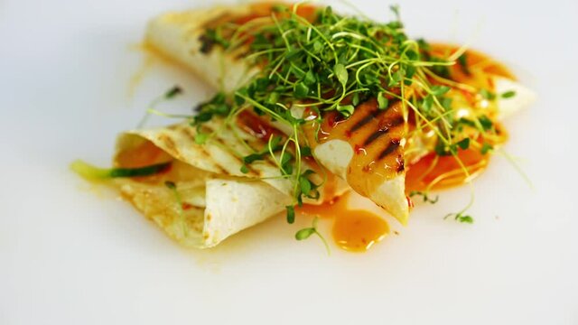 Fry pita bread on white plate. Shawarma fried on grill with microgreen on top. Tasty street food video.