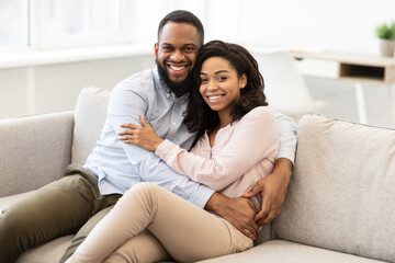 Obraz premium African american couple spending weekend together lying on sofa