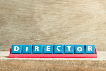 Tile letter on red rack in word director on wood background