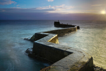 Sunset view under long exposure of St Monans break water pier. located in Fife, Scotland.