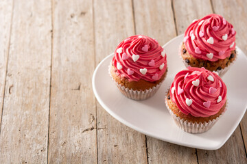 Cupcakes decorated with sugar hearts for Valentine's Day on wooden table. Copy space	