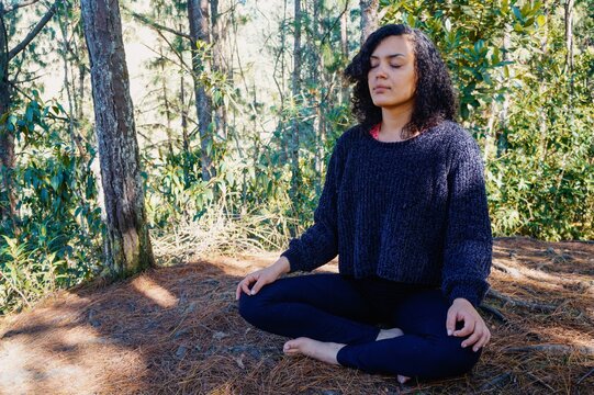 Mujer meditando en el bosque