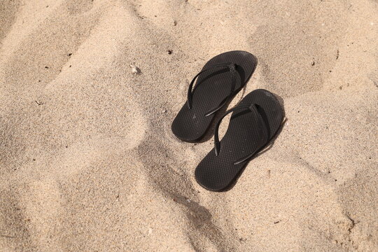 sandalias abandonadas en la arena del mar