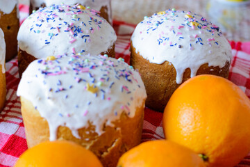 homemade Easter cakes with oranges on a table with a red cloth