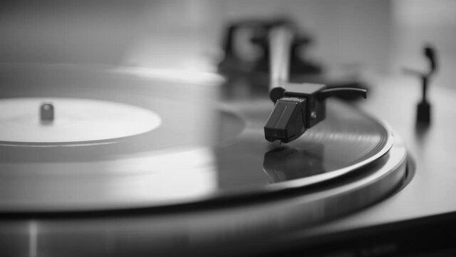Black and White. The needle goes down on a vintage vinyl record. The vinyl record is spinning. The needle plays on a vintage vinyl record. Old turntable