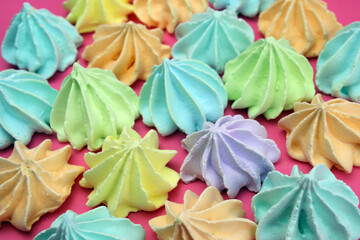 Colored meringues on a pink background. Desert, sweets Background, cake shop concept