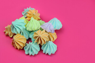 Colored meringues on a pink background. Desert, sweets, cake shop concept