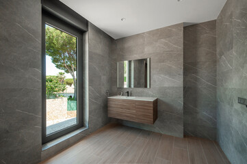 Modern gray shower room. Shower room without tray. Walls tiled with natural material.