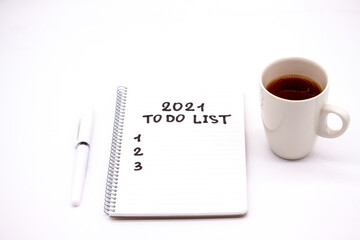 Notepad inscripted 2021 to do list with a pen on a white background close up