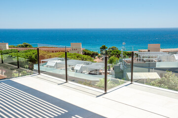 Sea view from a large terrace with a glass partition.