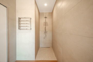 Modern shower room. Shower room without tray. Walls tiled with natural material.