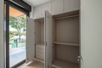 Built-in wardrobes design. Built-in empty wardrobes with open doors. New house, empty rooms.