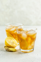 Summer party cocktail, iced lemon ginger tea in glasses. Space for text.
