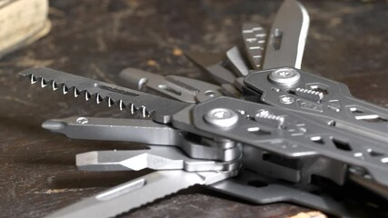 Multifunctional knife tool on wooden surface, camera tilting upwards